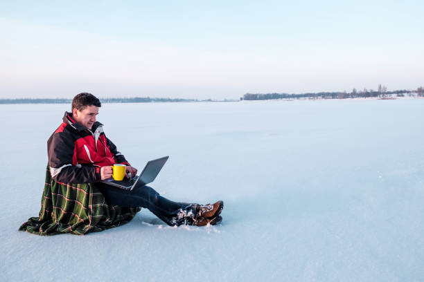 istock A freelancer man in warm jacket works with a laptop. 911291934