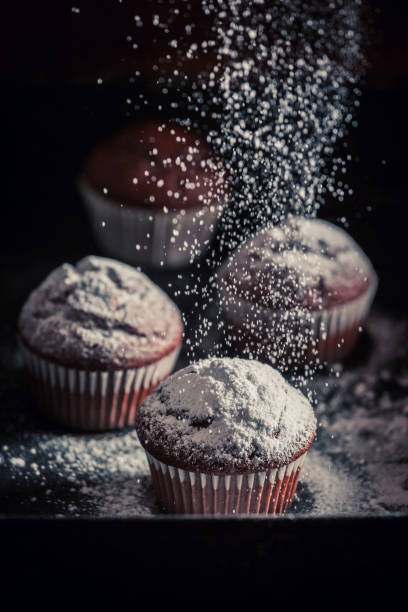 istock Falling powdered sugar on brown chocolate muffin 911292336