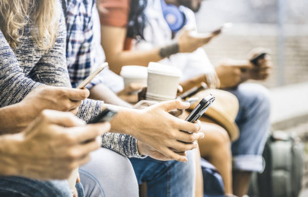 Multicultural friends group using smartphone with coffee at university college break - People hands addicted by mobile smart phone - Technology concept with connected trendy millennials - Filter image Multicultural friends group using smartphone with coffee at university college break - People hands addicted by mobile smart phone - Technology concept with connected trendy millennials - Filter image millennial generation stock pictures, royalty-free photos & images