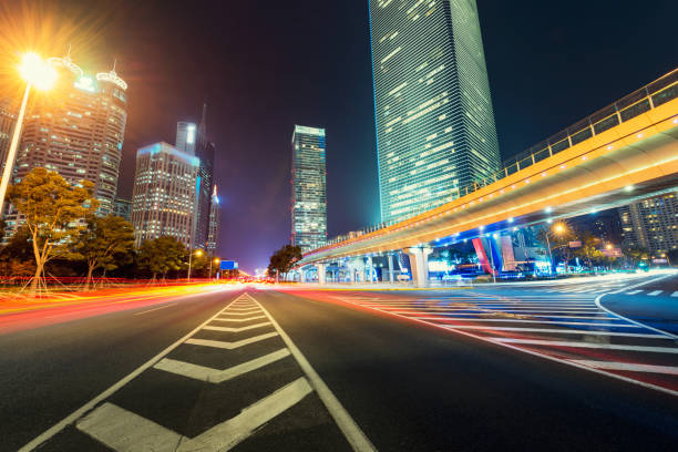 Abstract background of People across the crosswalk at night in Shanghai, China. Perfect background image of blurred night street with unrecognizable people and cars in night illumination