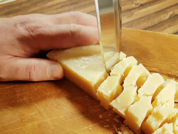 istock hands cut a knife parmesan cheese 911317052
