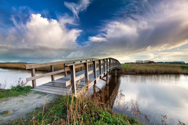 istock wooden bridge via river and blue sky in countryside 911318700