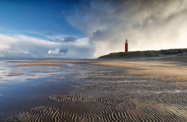 beautiful stormy sky over North sea beech and lighthouse stock photo