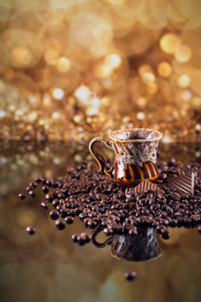 Cup of coffee on heap of roasted coffee beans.