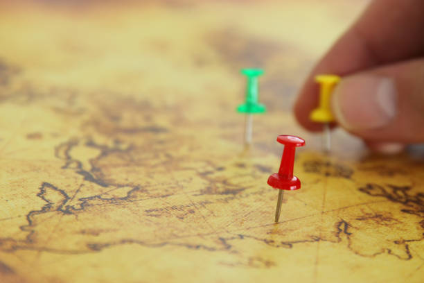 istock Image man's hand attached pins to a map, showing location or travel destination. selective focus. 911325988