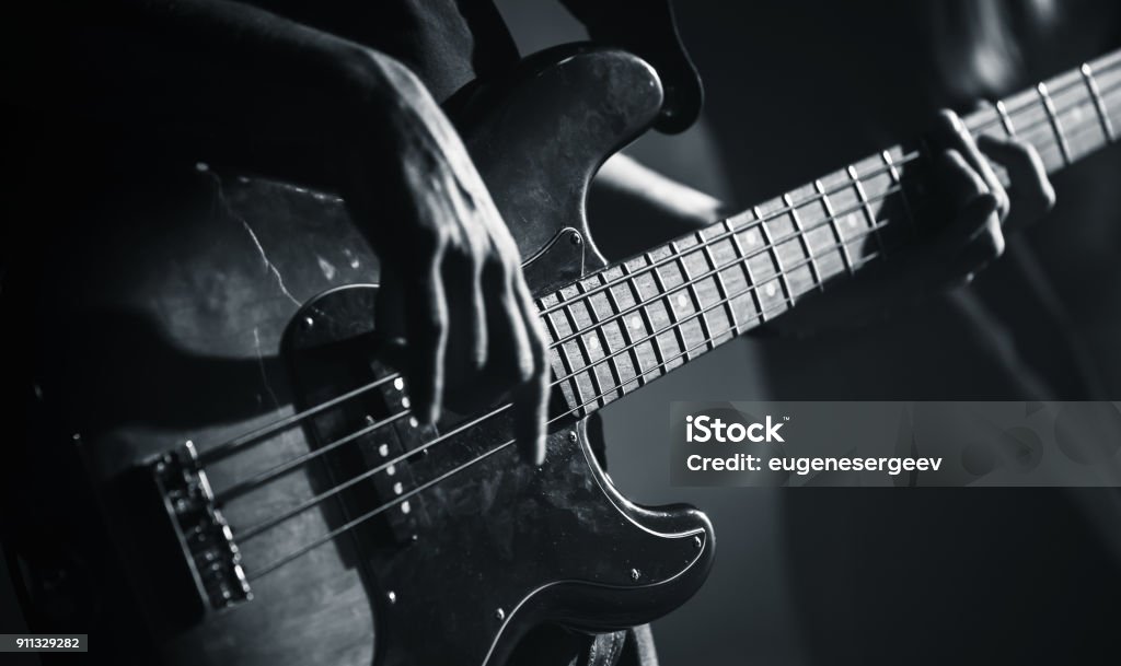 Electric bass guitar black and white photo Electric bass guitar player hands, live music theme, black and white photo Guitar Stock Photo