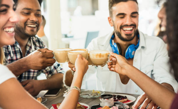 istock Friends group drinking latte at coffee bar restaurant - People talking and having fun together at fashion cafeteria - Friendship concept with happy men and women at cafe - Focus on cappuccino cups 911329670