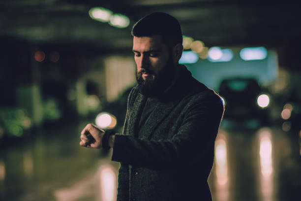 istock Man with beard waiting and looking at watch 911329742