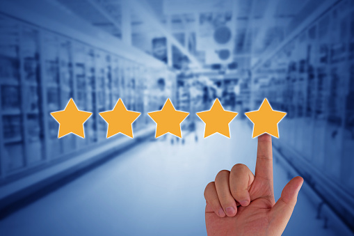 Customer experience concept, service rating on blue background, hand and yellow star