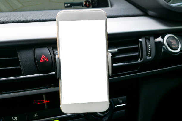 istock Smartphone in a car use for Navigate or GPS. Driving a car with Smartphone in holder. Mobile phone with isolatede white screen. Blank empty screen. copy space. Empty space for text. modern car interior details. 911338022