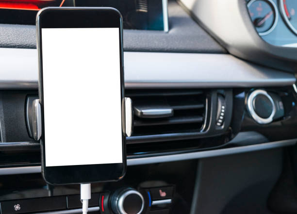 istock Smartphone in a car use for Navigate or GPS. Driving a car with Smartphone in holder. Mobile phone with isolated white screen. Blank empty screen. copy space. Empty space for text. modern car interior details. 911338032