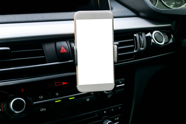 istock Smartphone in a car use for Navigate or GPS. Driving a car with Smartphone in holder. Mobile phone with isolatede white screen. Blank empty screen. copy space. Empty space for text. modern car interior details. 911338040