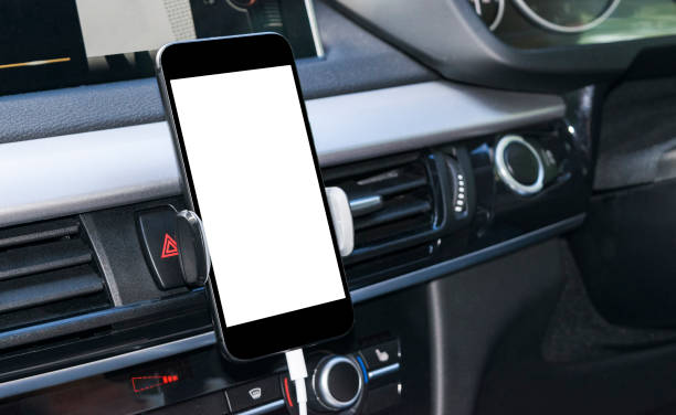 istock Smartphone in a car use for Navigate or GPS. Driving a car with Smartphone in holder. Mobile phone with isolatede white screen. Blank empty screen. copy space. Empty space for text. modern car interior details. 911338050