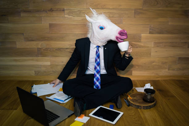 istock Funny unicorn in a suit and tie smiles and drinks coffee 911340388