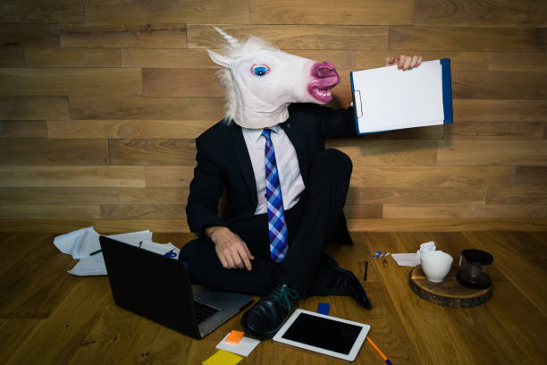 istock Young man in rubber mask sitting on the floor 911340452