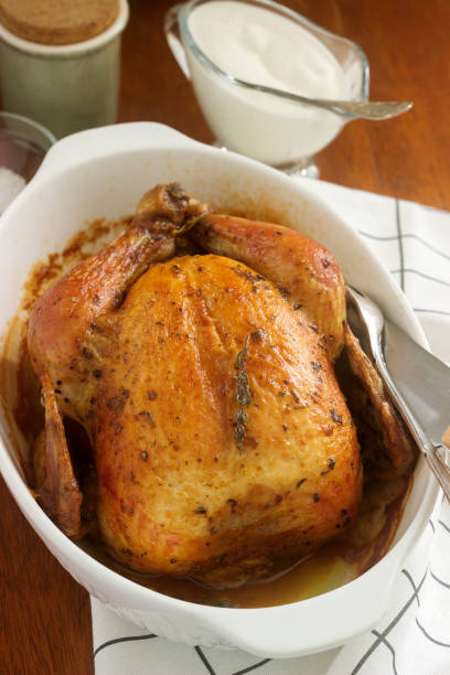 istock Baked chicken with herbs and garlic, served with sour cream sauce. Rustic style. 911348516
