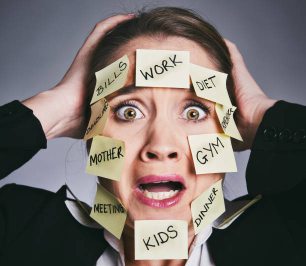 istock Multi-tasking woman clutches her head in desperation 911348960