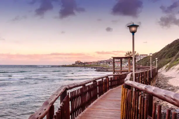 Boardwalk leads past beach and sea in Gonubie in the evening sun set