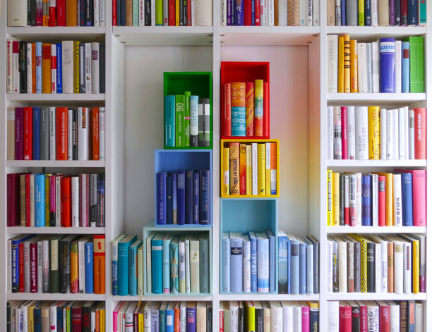 istock Library book shelves packed with colorful books and some colorful boxes 911352616