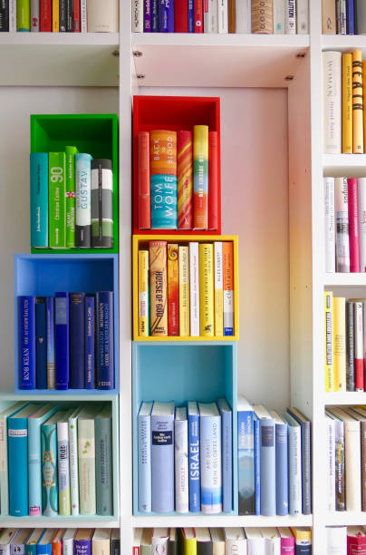 istock Library book shelves packed with colorful books and some colorful empty boxes 911352700