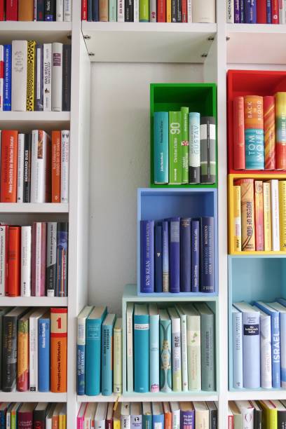 istock Library book shelves packed with colorful books and some colorful empty boxes 911352792