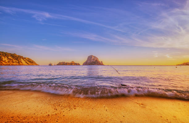 Waves crashing at the beach at Cala d´Hort on Ibiza at sunset