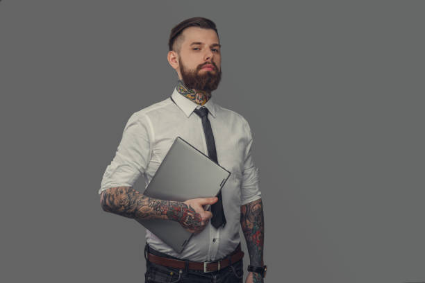 Bearded Tattoed Man In White Shirt Holding Laptop Stock Photo - Download  Image Now - Tattoo, Men, Hipster Culture - iStock