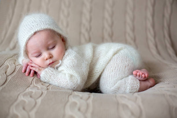 istock Beatiful baby boy in white knitted cloths and hat, sleeping 911366732