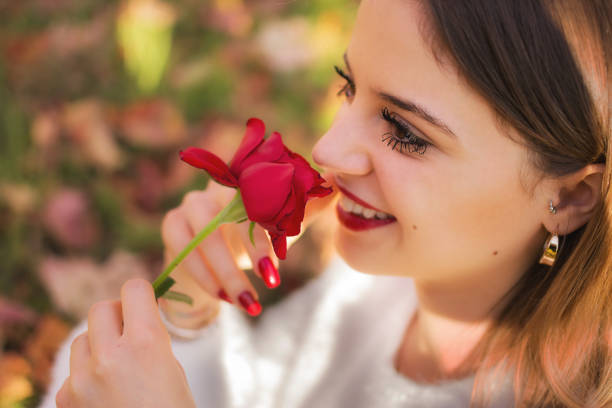 istock Girl sniffing a red rose 911366944