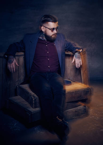 istock Glamorous bearded man in sunglasses posing in studio. 911369244