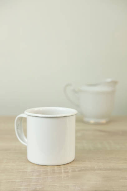 istock WHITE ENAMEL COFFEE MUG WITH CERAMIC MILK JAR 911369596