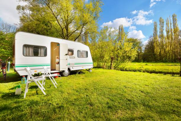 istock Caravan trailer on a green lawn, on a sunny spring day 911397680