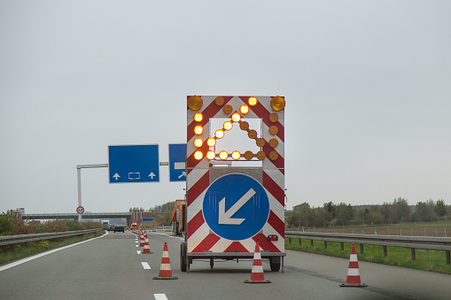 Road sign on a highway, with a light up arrow.