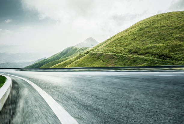 viaggio su strada vuoto attraverso la catena montuosa,movimento sfocato - foto stock