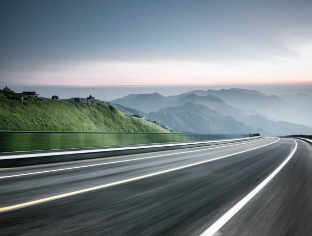 viaggio su strada vuoto attraverso la catena montuosa,movimento sfocato - foto stock