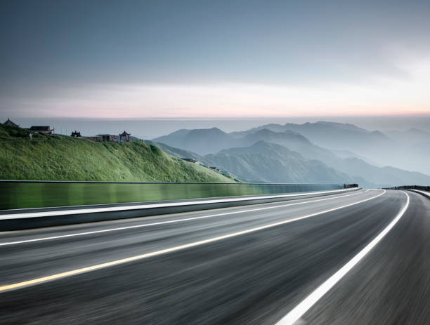 empty road travel through mountain range,blurred motion stock photo