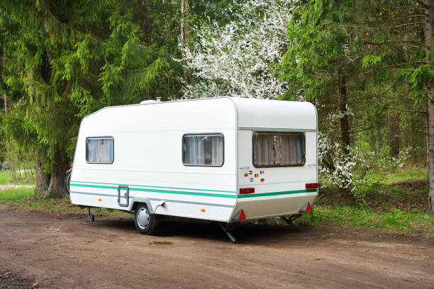 istock Caravan trailer on a forest road, on a sunny spring day 911399112