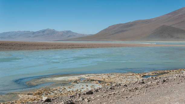 istock Laguna y Termas de Polques hot spring pool with Salar de Chalviri in background, Salar de Uyuni, Potosi, Bolivia - South America 911399680