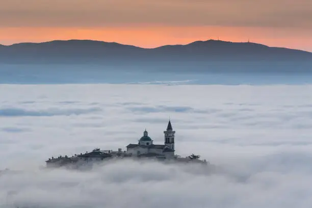 View of Trevi in Umbria (Italy) at sunset with fog.