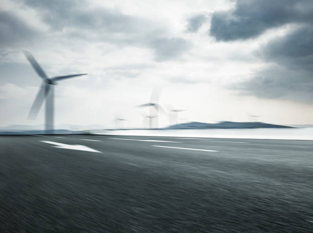 istock blurred motion highway with windmills against cloudy sky 911409924