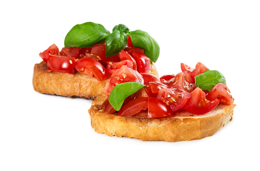 Two bruschetta with fresh tomato and basil isolated on white background.