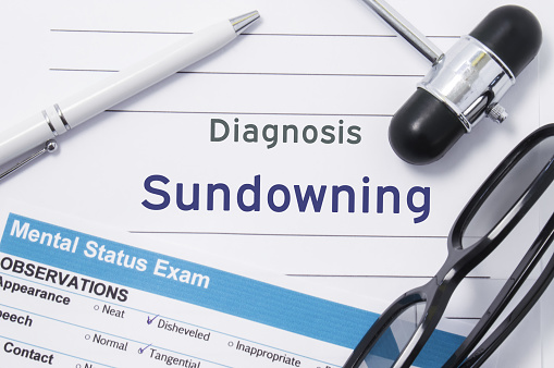 Diagnosis Sundowning. Medical note surrounded by neurologic hammer, mental status exam with an inscription in large letters psychiatric diagnosis of Sundowning. Concept photo for psychiatry