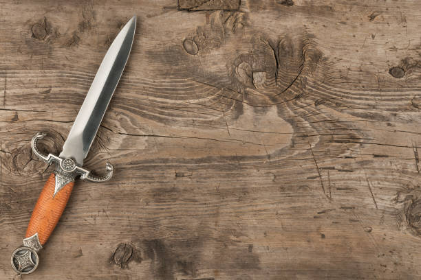 istock Knife, dagger on a wooden surface, with a place for your text. 911426492