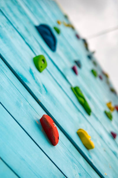 istock Wall with climbing holds in gym, vertical 911435972