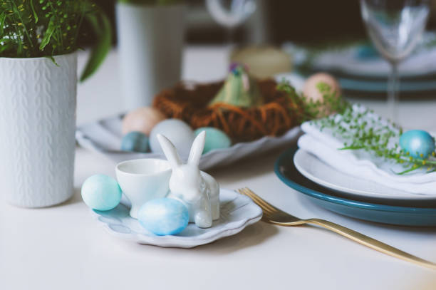 istock easter and spring festive table in nordic scandinavian style, decorated in blue and white natural tones with eggs, bunny, fresh flowers and candles. 911439674