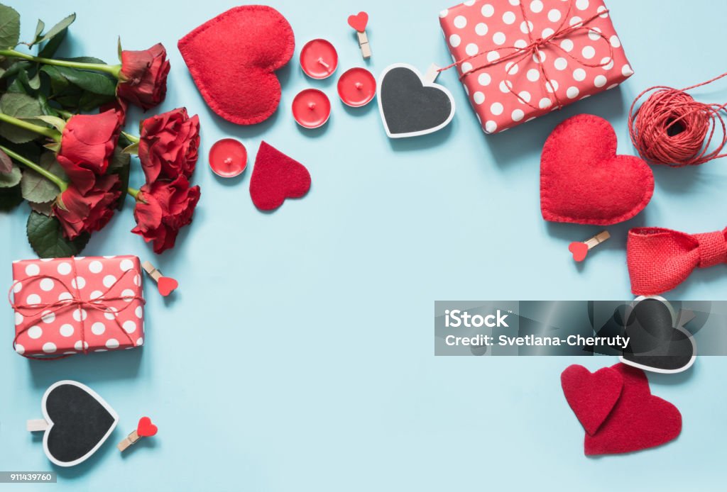 Valentine's day greeting card. Composition with gifts, roses, red hearts on blue surface. Top view. Copy space. Valentine's day card. Composition with gifts, red hearts on blue surface. Top view. Copy space. Valentine's Day - Holiday Stock Photo
