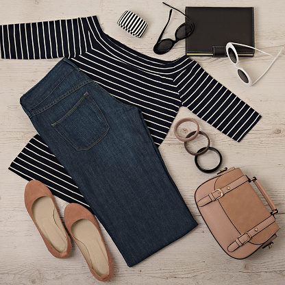 Female summer outfit - navy jeans, striped top, sunglasses, backpack. Selective focus.