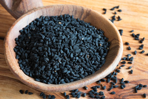 istock Black cumin seeds on a wooden spoon 911448264