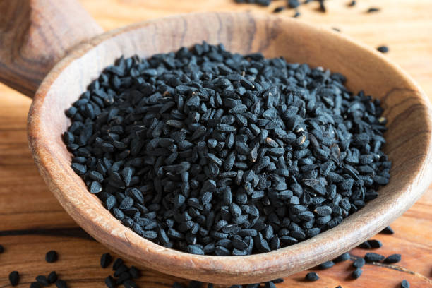 istock Black cumin seeds on a wooden spoon 911448266