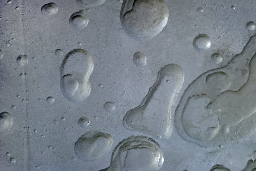 background, texture - gray rough concrete wall with caverns, reminiscent of the lunar surface